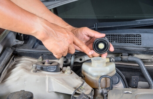 A mobile brake mechanic in Sydney inspecting a brake fluid reservoir