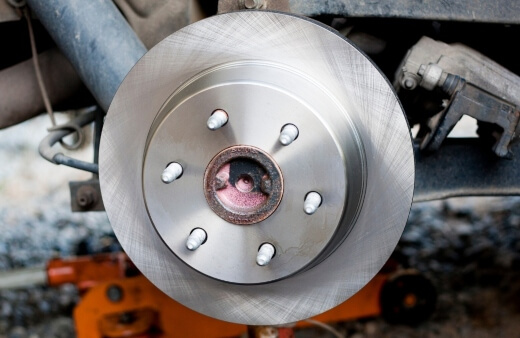 A newly installed brake rotor on a vehicle by a mobile brake specialist