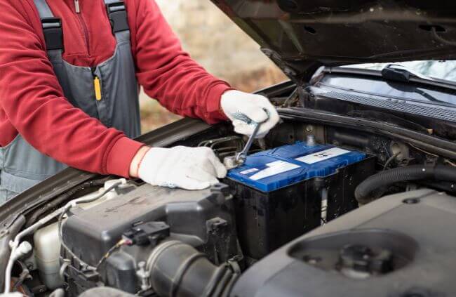 A mobile mechanic in Liverpool carrying out a car battery replacement as part of a mobile service.