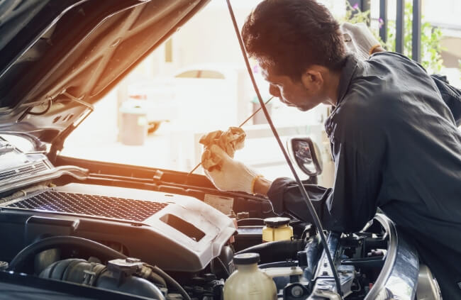 An expert Mobile Mechanic in Cabramatta carefully inspecting the engine and checking the oil levels to ensure optimal vehicle performance