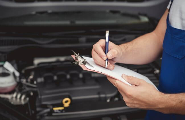 Pre-purchase vehicle inspections by a mobile mechanic in Campbelltown, carefully completing a checklist to ensure the car is in top condition before purchase.