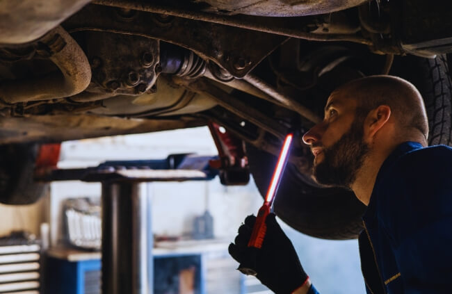 Mobile Mechanic Penrith technician carefully inspecting a vehicle's underbody during a car service in Werrington.