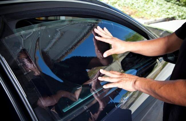 Technician applying window film during a mobile car window tinting service in Sydney, provided by Mobile Mechanic Penrith.